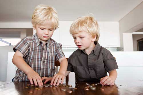 Young boys playing a math game by counting coins