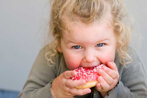 Chubby girl eating a donut